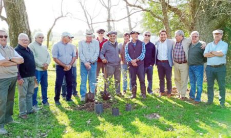 Los antiguos alumnos junto a los árboles a plantar