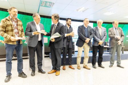 Pablo Perdomo de CAF le entrega el documento a Orsi